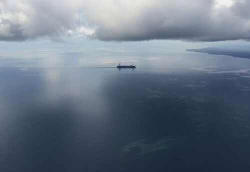 Ölverschmutztes Wasser im Schwarzen Meer mit dunklen Wolken.