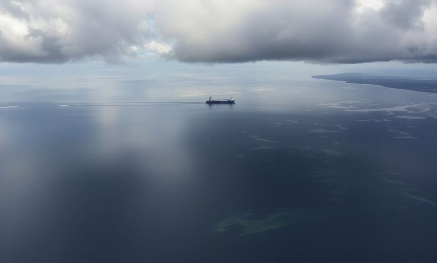 Ölverschmutztes Wasser im Schwarzen Meer mit dunklen Wolken.