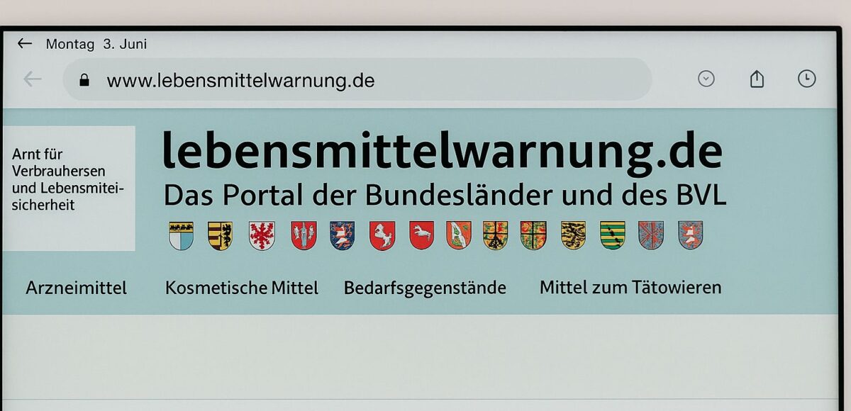 Ein Bildschirm zeigt die Website lebensmittelwarnung.de, das offizielle Portal der Bundesländer und des BVL für Rückrufe und Verbraucherwarnungen. Oben sind die Wappen der Bundesländer zu sehen, darunter Kategorien wie Arzneimittel und Lebensmittel.