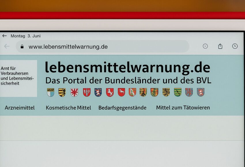 Ein Bildschirm zeigt die Website lebensmittelwarnung.de, das offizielle Portal der Bundesländer und des BVL für Rückrufe und Verbraucherwarnungen. Oben sind die Wappen der Bundesländer zu sehen, darunter Kategorien wie Arzneimittel und Lebensmittel.