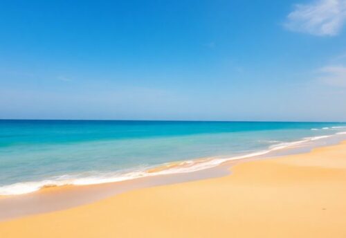 Türkisblaue Wellen brechen an einem sandigen Strand.