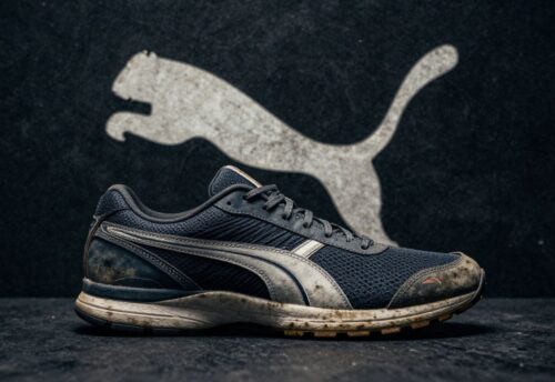 Puma Logo und abgenutzter Schuh auf dunklem Hintergrund