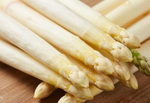 Frischer weißer und grüner Spargel auf Holzhintergrund